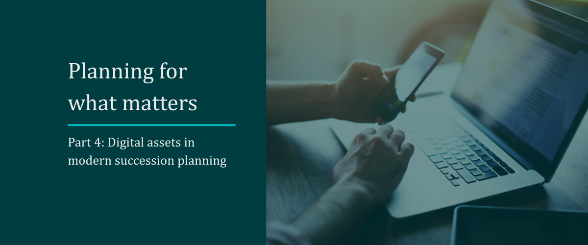 man on laptop with phone in hand